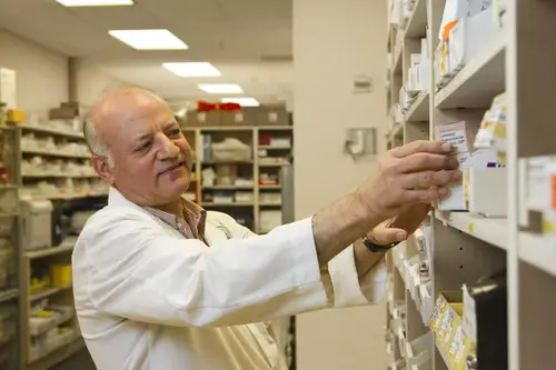 A pharmacist retrieving medicine needed for a cancer patient.
