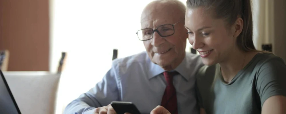 A young woman helping an older man sign up for Final Expense Life Insurance.