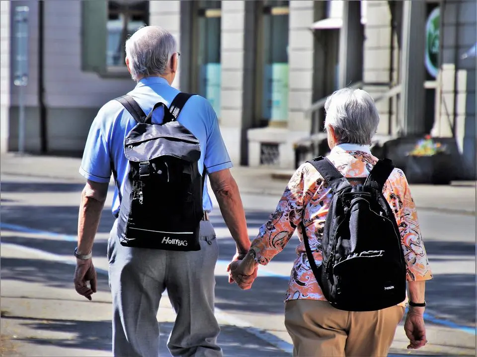 An elderly couple walking after a knee replacement surgery.