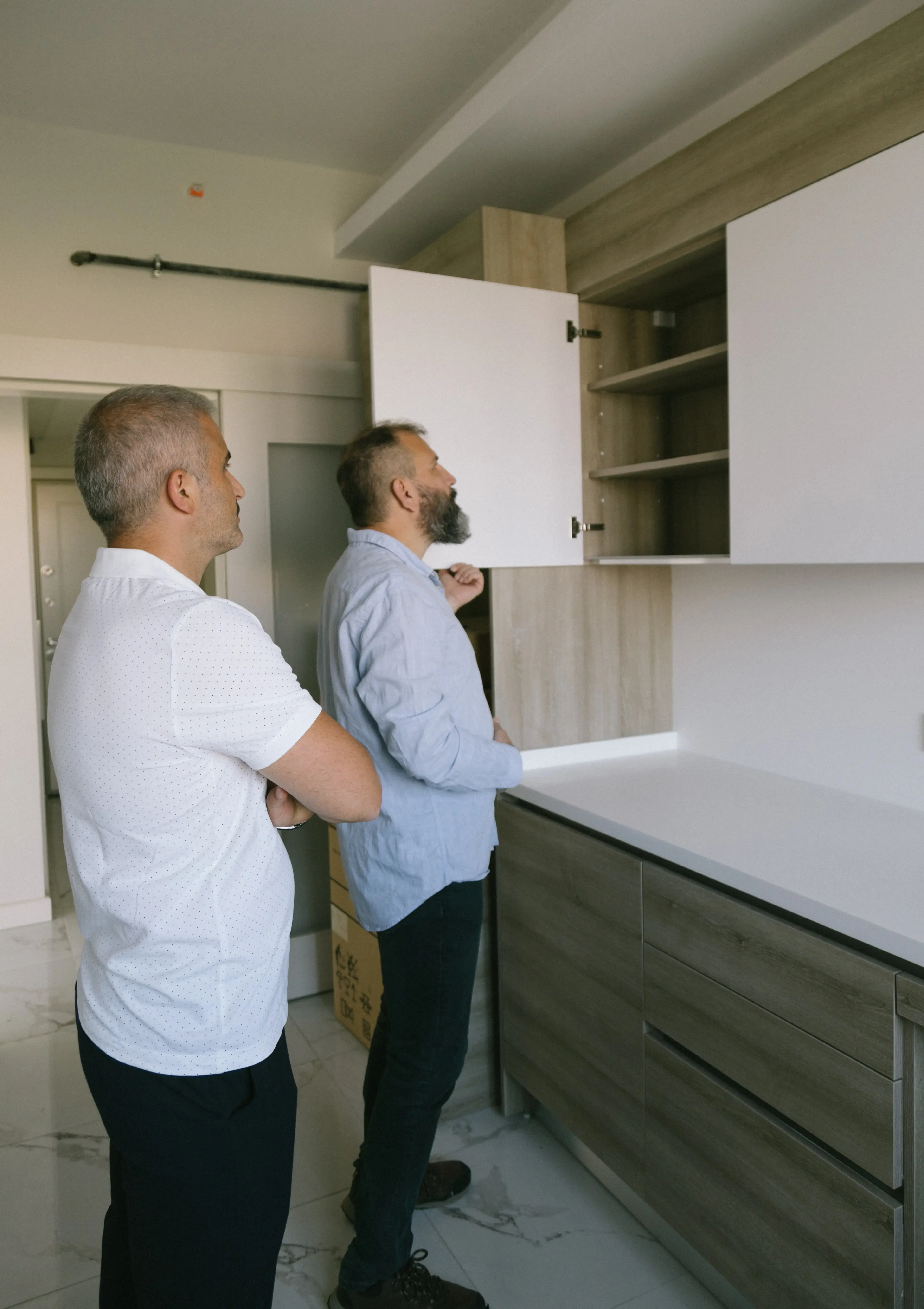 Men Checking the Wooden Cabinet of a House During an Interior Inspection during the Home Inspection