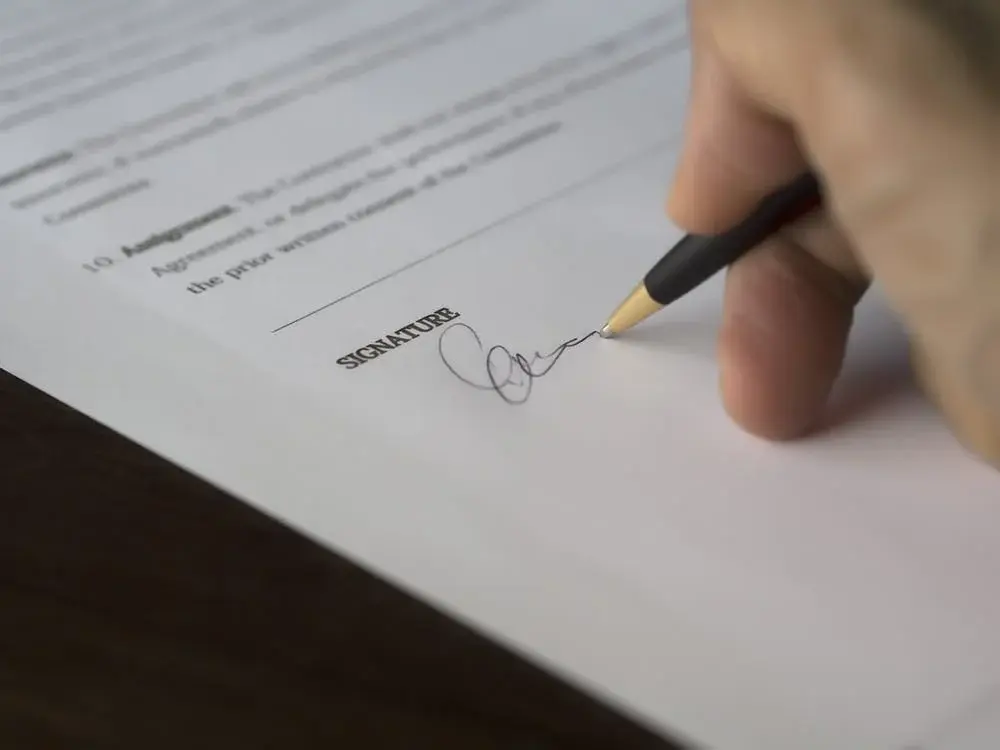 A person signing the papers to sell their Life Insurance.
