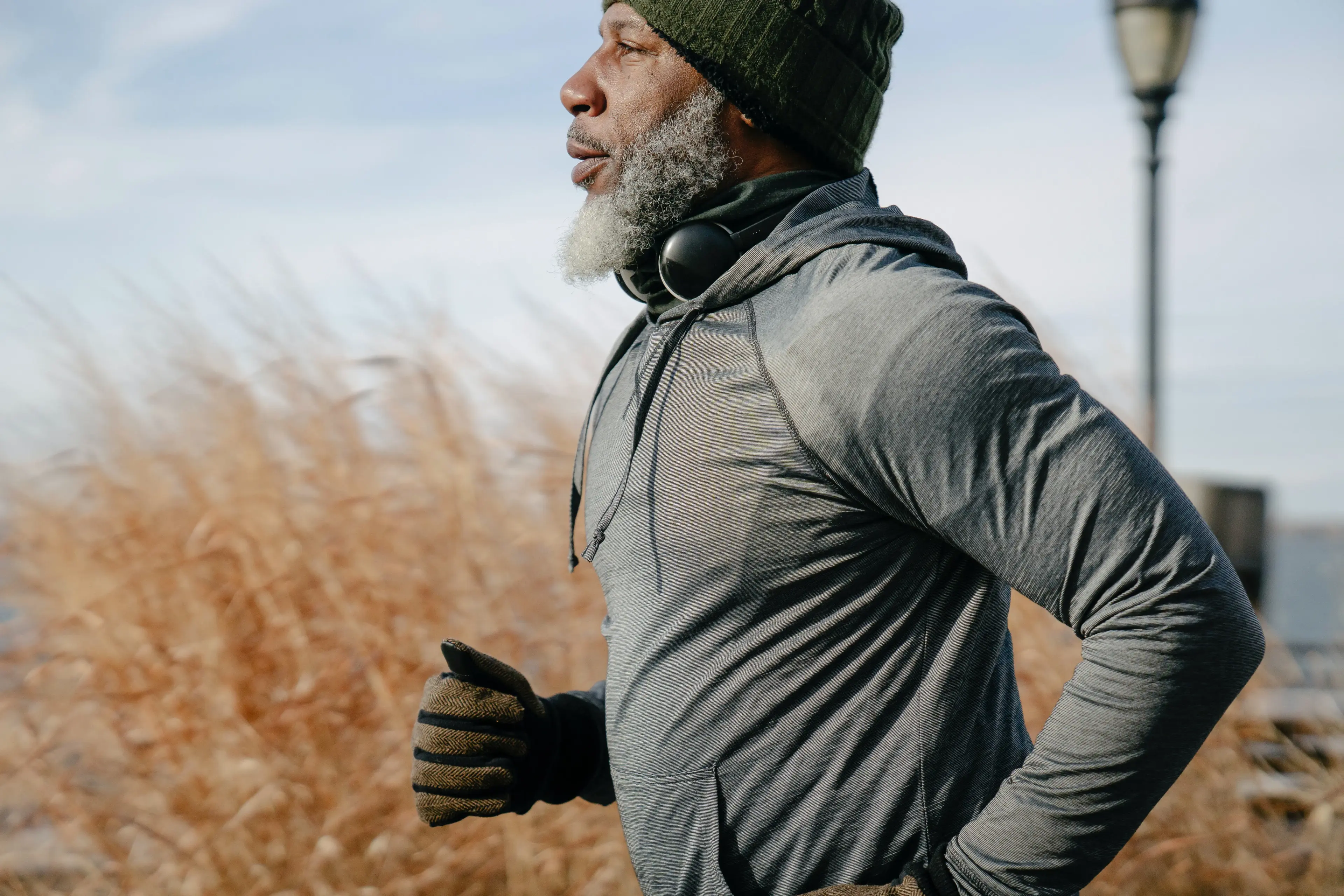 Black man in sportswear jogging in sunny autumn day