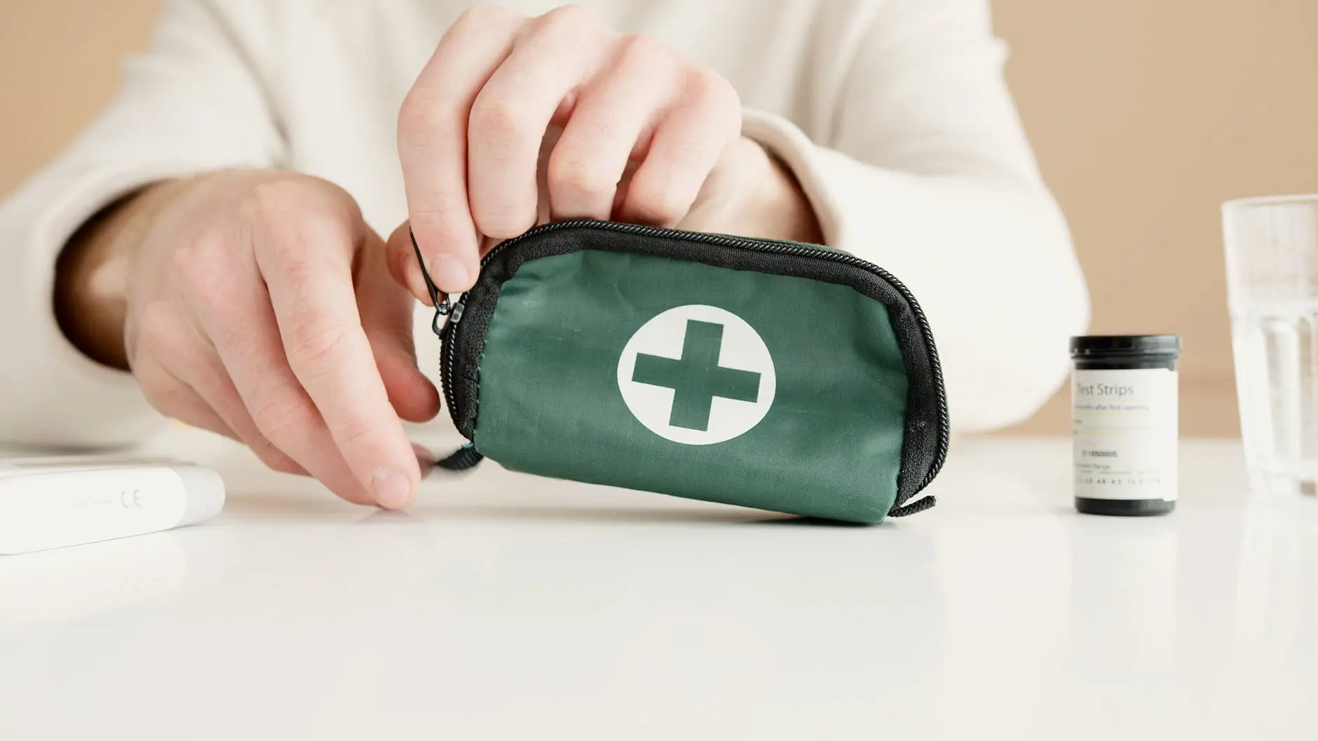 A doctor that is zipping up a first aid kit.
