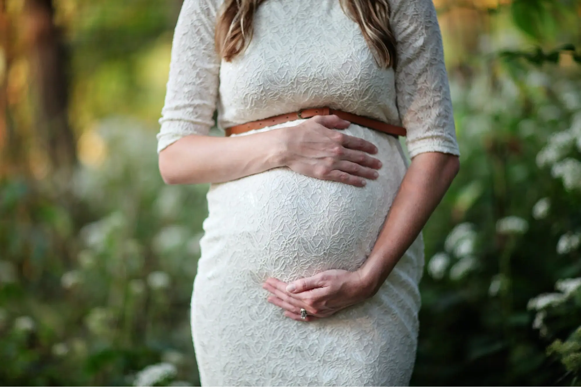 A woman that is pregnant holding her stomach.