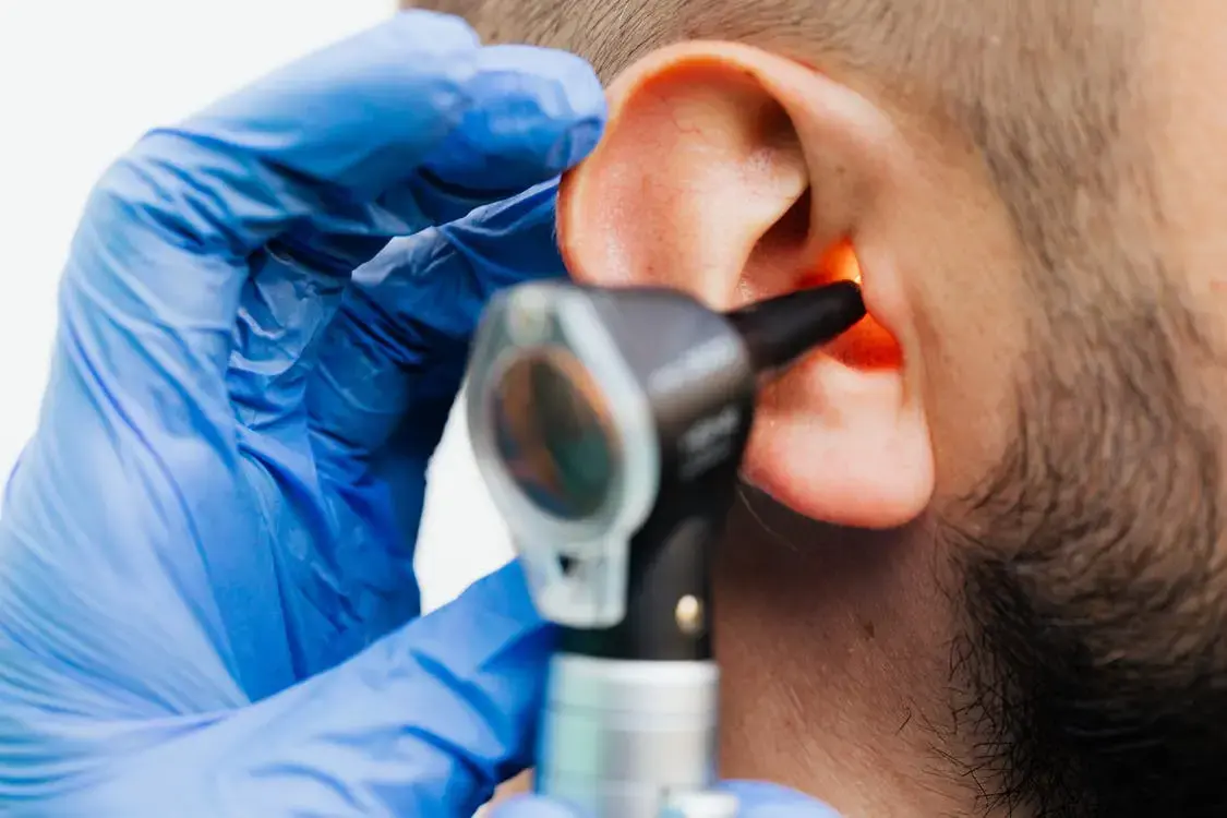 A man that is getting his hearing tested by a doctor.