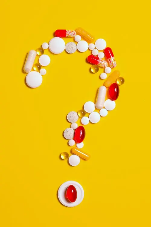 A pattern of pills in the shape of a question mark.