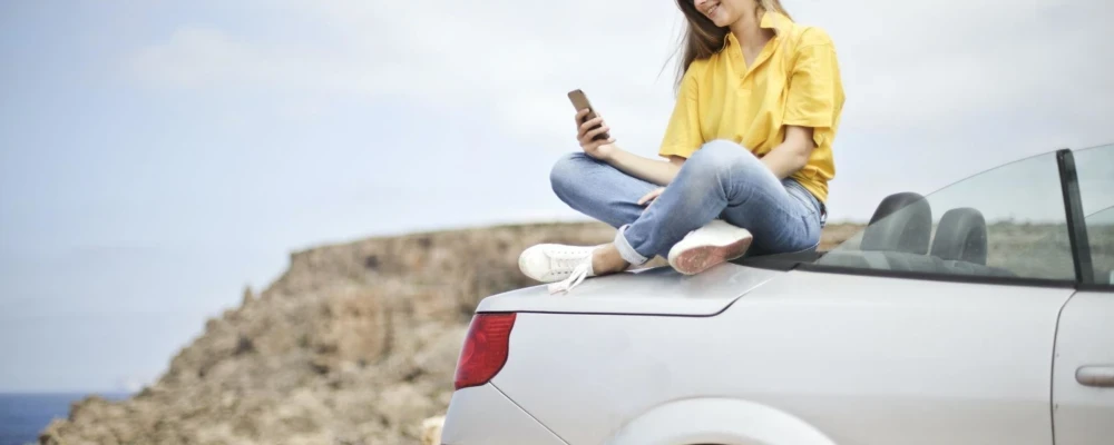 Girl Sitting on parked car boot